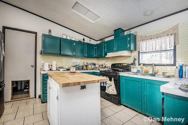 kitchen featuring black gas range, light tile patterned floors, wooden counters, and sink