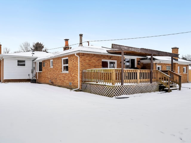 snow covered house featuring a deck