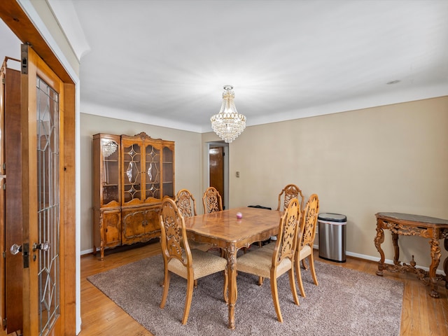 dining space with hardwood / wood-style flooring and an inviting chandelier