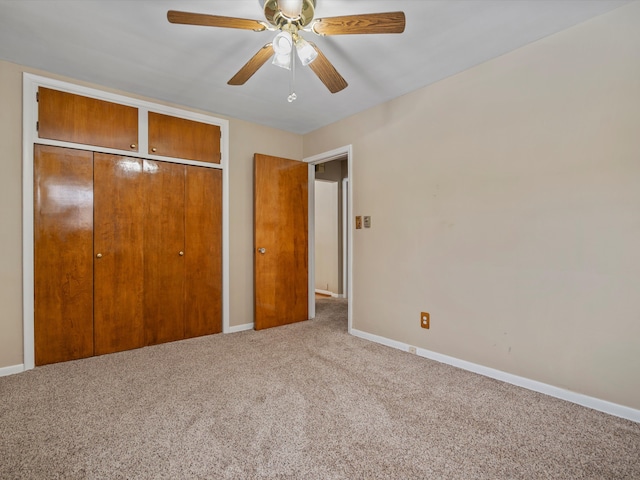 unfurnished bedroom featuring ceiling fan, a closet, and carpet flooring