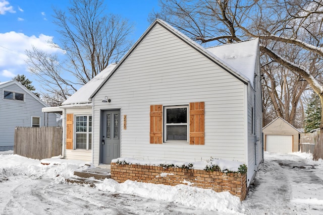 bungalow with a garage and an outbuilding