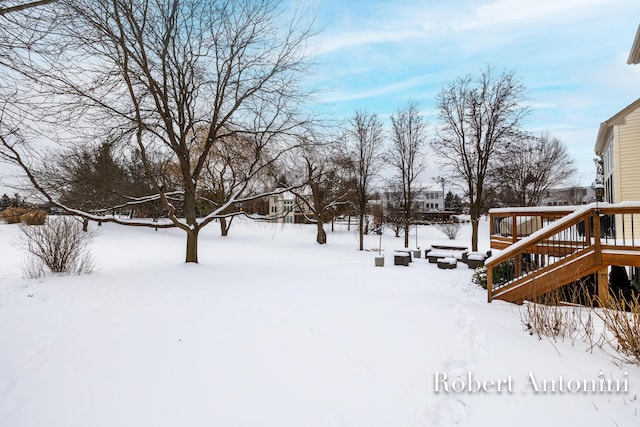 snowy yard with a wooden deck