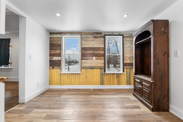 interior space featuring light hardwood / wood-style flooring and wood walls