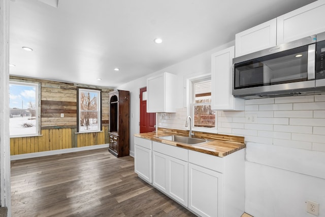 kitchen featuring white cabinets, butcher block counters, and sink