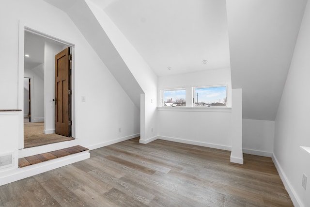 additional living space with light wood-type flooring and lofted ceiling