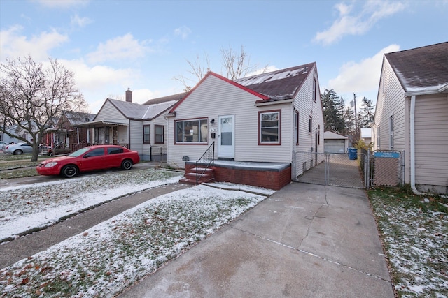 bungalow-style house with a garage and an outbuilding