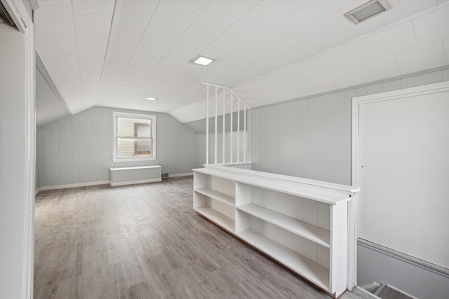 additional living space featuring hardwood / wood-style floors, radiator heating unit, and vaulted ceiling