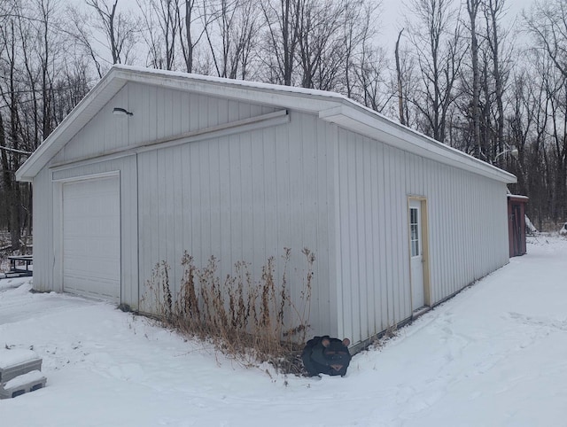 snow covered structure with a garage