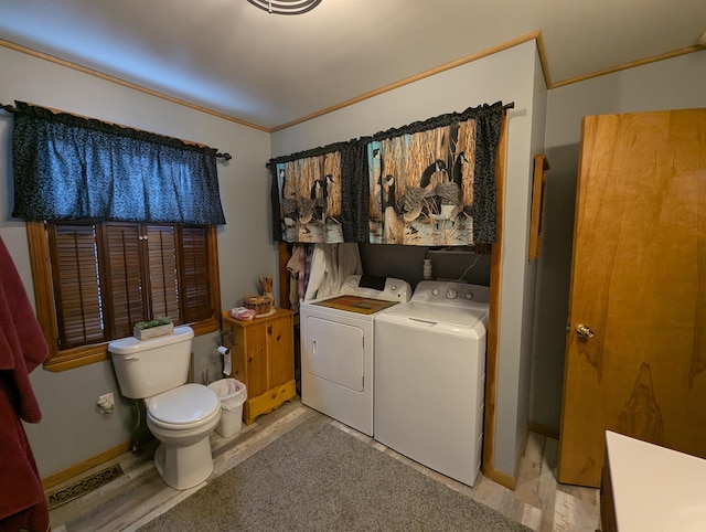 laundry room featuring crown molding and washing machine and clothes dryer