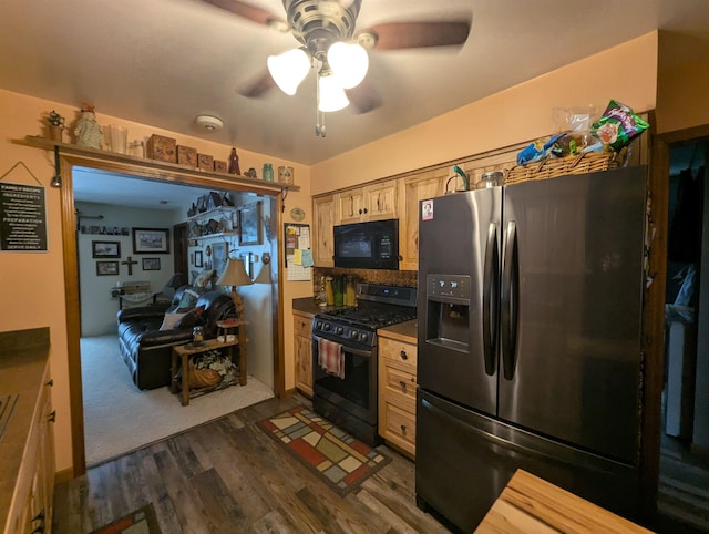 kitchen featuring dark wood-type flooring, stainless steel refrigerator with ice dispenser, gas range oven, and ceiling fan