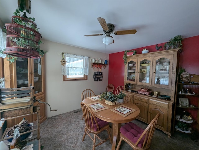 carpeted dining area with ceiling fan