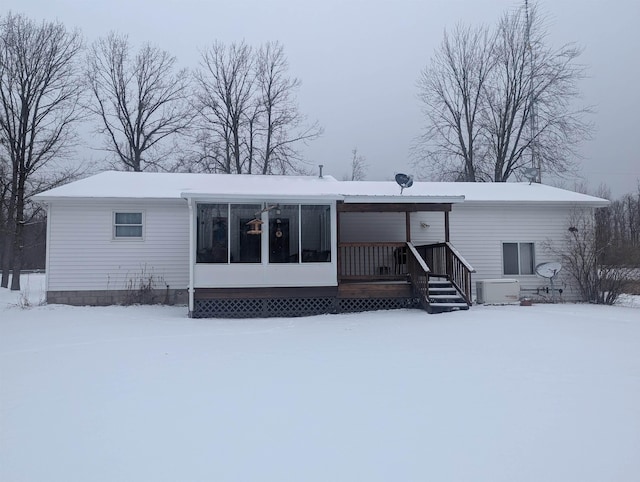 snow covered rear of property featuring cooling unit