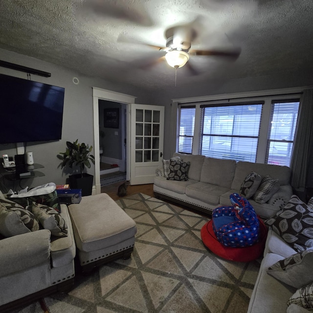 living room with ceiling fan and a textured ceiling