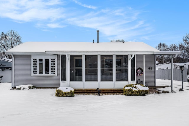 snow covered house with a sunroom