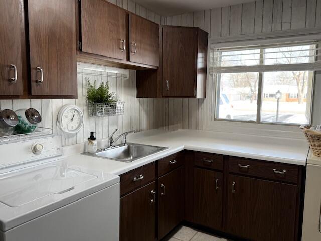 kitchen featuring sink, light tile patterned floors, range, and dark brown cabinets