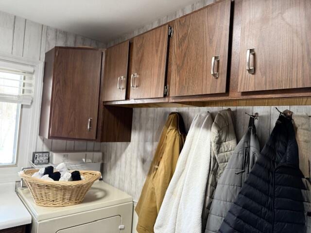 clothes washing area featuring washer / dryer and cabinets