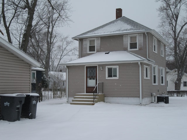 snow covered property featuring central AC