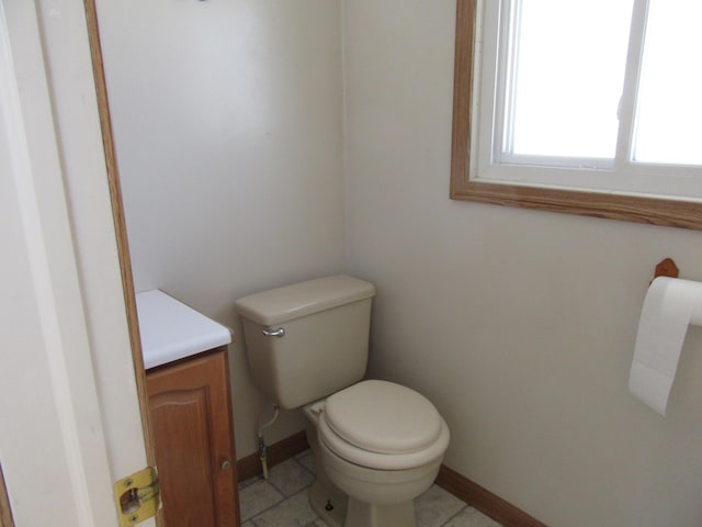 bathroom with toilet, vanity, and tile patterned flooring