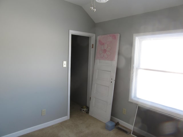 unfurnished bedroom with light carpet and vaulted ceiling