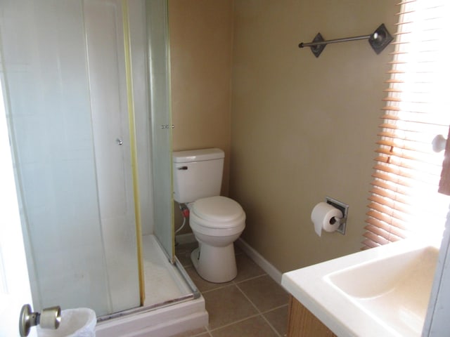 bathroom with a shower with shower door, sink, tile patterned floors, and toilet