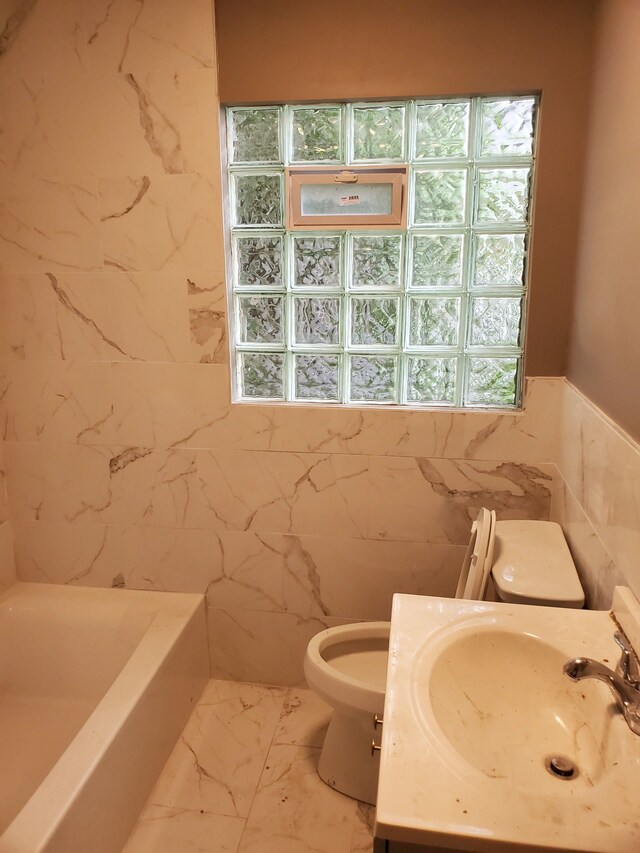 bathroom with toilet, vanity, tile walls, and a bathing tub