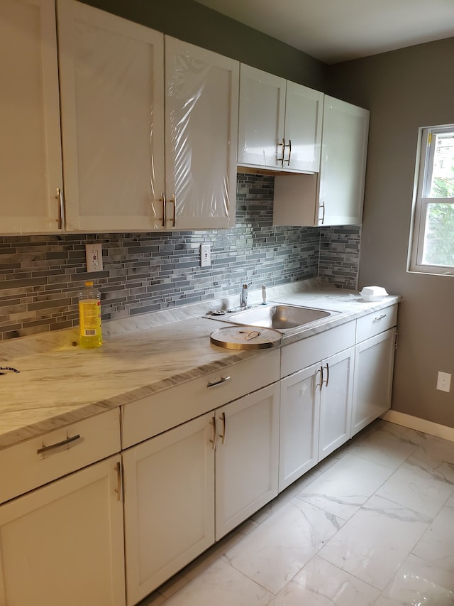 kitchen with sink, white cabinets, and tasteful backsplash