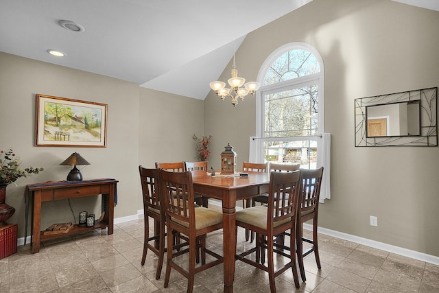 dining room with lofted ceiling and a chandelier