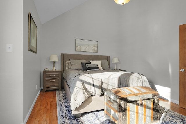 bedroom with lofted ceiling and hardwood / wood-style floors