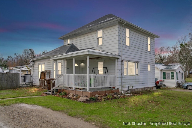 view of front of property featuring covered porch and a yard