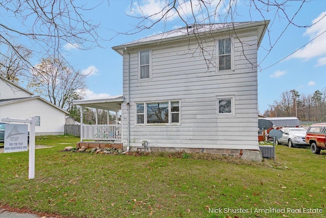 back of property featuring a lawn and a porch