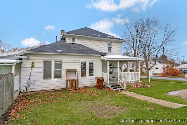 back of property with a yard and a porch