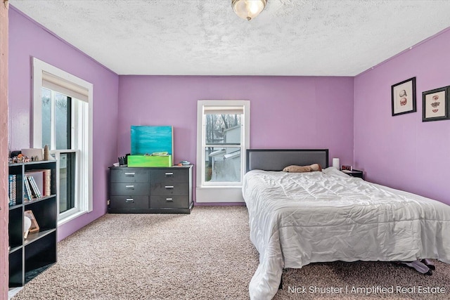 carpeted bedroom with a textured ceiling and multiple windows