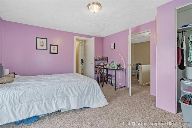 bedroom featuring a textured ceiling and light colored carpet