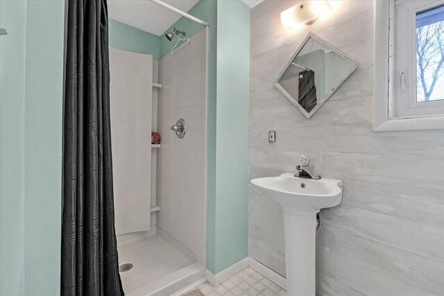 bathroom with a stall shower and a sink