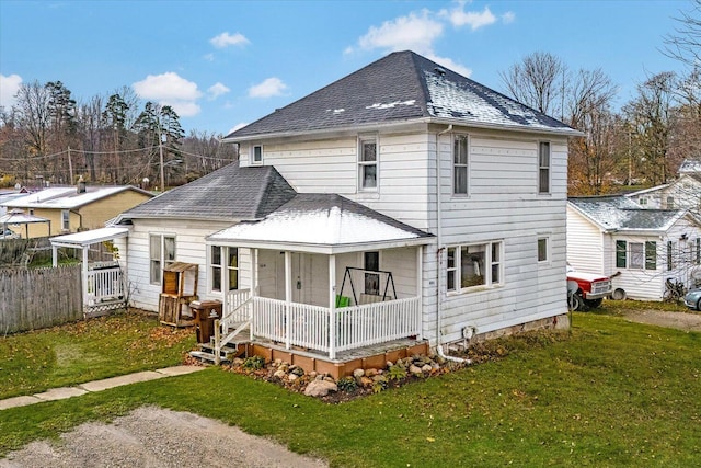 rear view of property with roof with shingles and covered porch