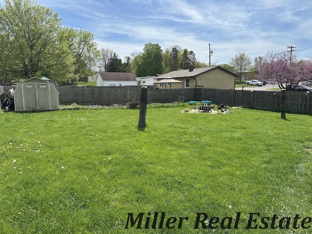 view of yard featuring a shed, an outbuilding, and an outdoor fire pit