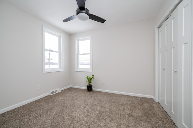 unfurnished bedroom with ceiling fan and carpet