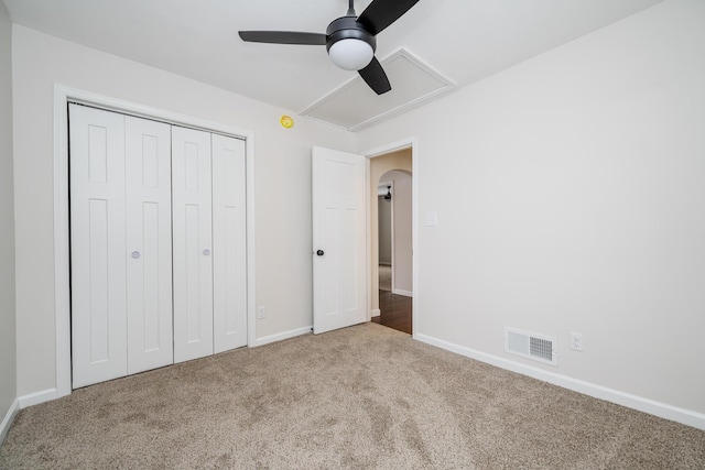 unfurnished bedroom with light carpet, ceiling fan, and a closet