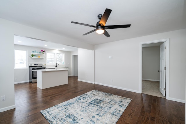 unfurnished living room with ceiling fan and dark hardwood / wood-style floors