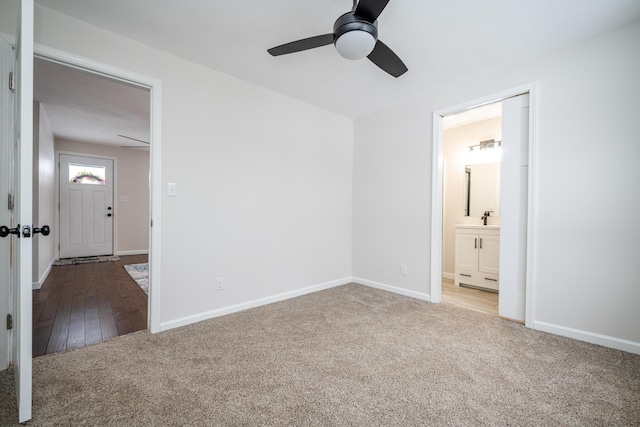 unfurnished bedroom featuring ceiling fan, sink, ensuite bathroom, and carpet floors