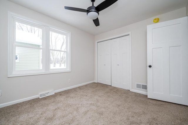 unfurnished bedroom featuring ceiling fan, light carpet, and a closet