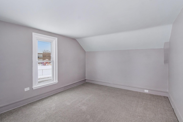 bonus room with lofted ceiling and carpet floors