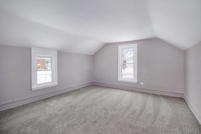 additional living space with carpet floors, plenty of natural light, and vaulted ceiling