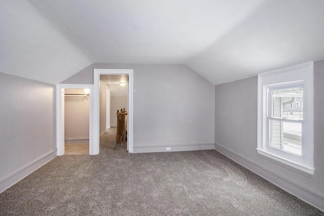 additional living space featuring carpet and lofted ceiling