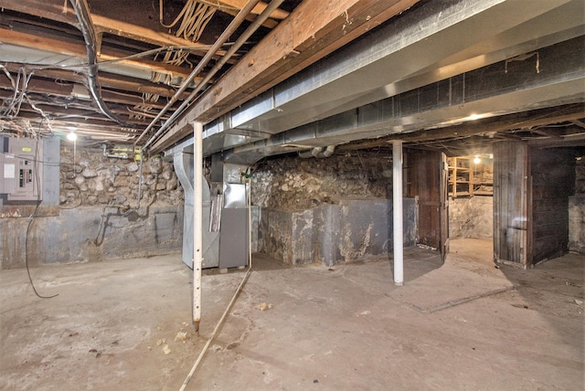 basement featuring heating unit and electric panel