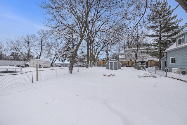 yard covered in snow featuring a storage unit