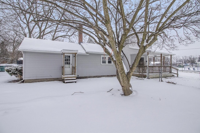 view of snow covered back of property