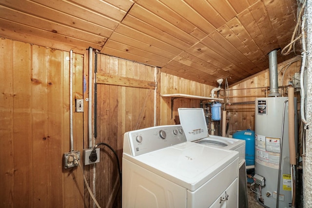 laundry area with wooden ceiling, separate washer and dryer, water heater, and wooden walls