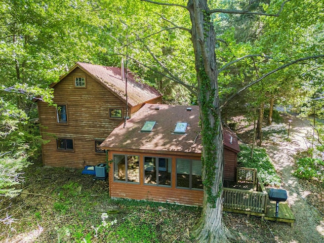 back of property with central AC unit and a deck