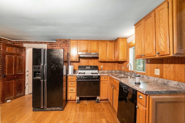 kitchen featuring sink, brick wall, black appliances, and light wood-type flooring